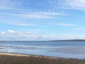 A coastal landscape with a clear sky and calm sea.