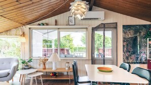 Un rincón comedor acogedor con una mesa de madera, sillas negras y una lámpara colgante.