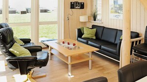 A modern living room with a black leather sofa, a wooden coffee table, and a black leather chair. - Modern Holiday Home in Faaborg With Balcony (Faaborg)