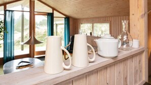 A wooden interior with a long counter displaying white ceramic mugs, a teapot, and a glass vase. - 4 Person Holiday Home in Blokhus (Blokhus)