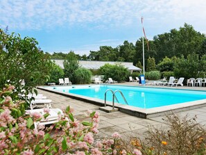A swimming pool with lounge chairs and a flagpole. - 4 Person Holiday Home in Nexo (Nexø)