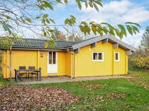A yellow building with a tiled roof, a door, and a window. There is a table and chairs outside. - Reposeful Holiday Home in Skjern near Sea (Skjern)