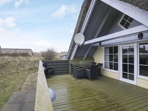 A covered outdoor area with a table and chairs, a satellite dish, and a window.