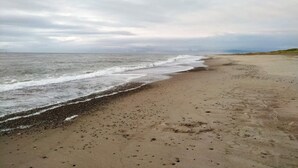 Une plage au rivage de galets et aux vagues déferlantes.