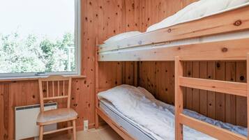 Habitación con literas, una ventana, un escritorio y una silla.