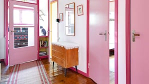 A room with pink walls, a wooden dresser, a mirror, and a door leading outside. - 8 Person Holiday Home in Salen (Salen)