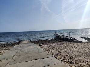 A concrete pathway leading to a pier extending into calm waters, with a clear sky above. - Lovely Holiday Home in SpÃ¸ttrup near Sea (Spøttrup)