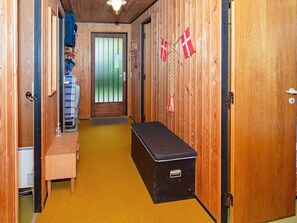 A narrow hallway with a bench, a small table, and a door with a window. - Lovely Holiday Home in SpÃ¸ttrup near Sea (Spøttrup)