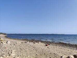 A pebbly beach with a clear sky and calm sea. - Lovely Holiday Home in SpÃ¸ttrup near Sea (Spøttrup)