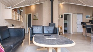 Un interior moderno con un sofá, una mesa, una chimenea y una zona de cocina.
