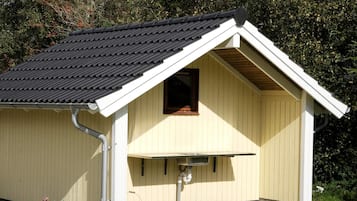 A small, single-story building with a sloped roof and a window.
