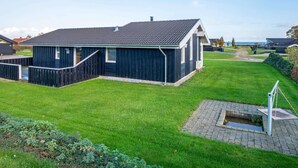 A single-story building with a dark exterior, a sloped roof, and a small porch. - 6 Person Holiday Home in Sjolund-by Traum (Sjølund)