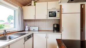 A compact kitchen with a sink, a toaster, a coffee maker, and a microwave. - Holiday Home in Groemitz (Groemitz)