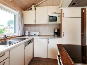 A compact kitchen with a sink, a toaster, a coffee maker, and a microwave. - Holiday Home in Groemitz (Groemitz)