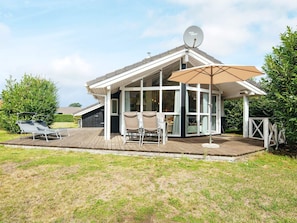 A modern house with a covered patio, a satellite dish, and outdoor furniture.