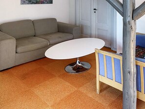 A room with a sofa, a small round table, and a wooden bench. - 16 Person Holiday Home in Aabenraa (Aabenraa)