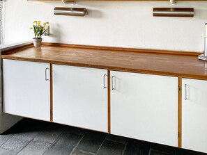 A kitchen with white cabinets, a wooden countertop, and a potted plant. - 16 Person Holiday Home in Aabenraa (Aabenraa)