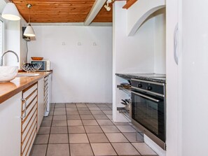 A kitchen with a wooden countertop, a sink, a microwave, and a double oven. - 16 Person Holiday Home in Aabenraa (Aabenraa)