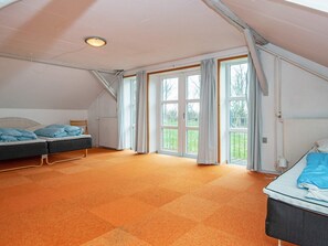 A room with two beds, large windows, and an orange carpet. - 16 Person Holiday Home in Aabenraa (Aabenraa)