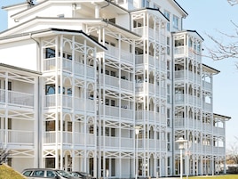 Un edificio de varios pisos con balcones y una entrada en esquina.