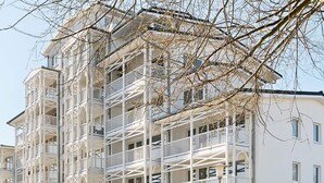 A multi-story building with balconies and a white facade. - Holiday Home in Grossenbrode (Grossenbrode)