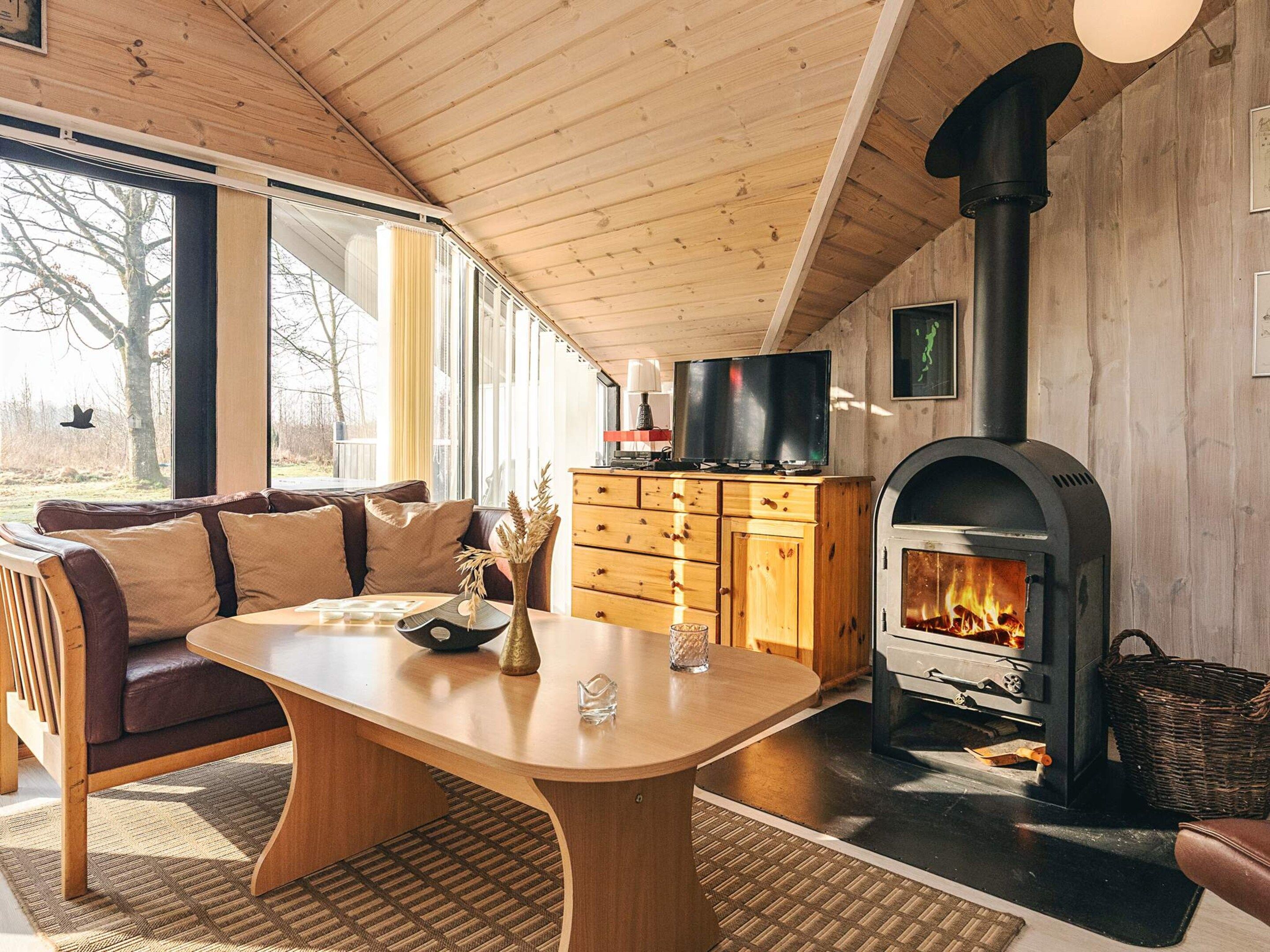 A cozy living room with a fireplace, wooden furniture, and a television.