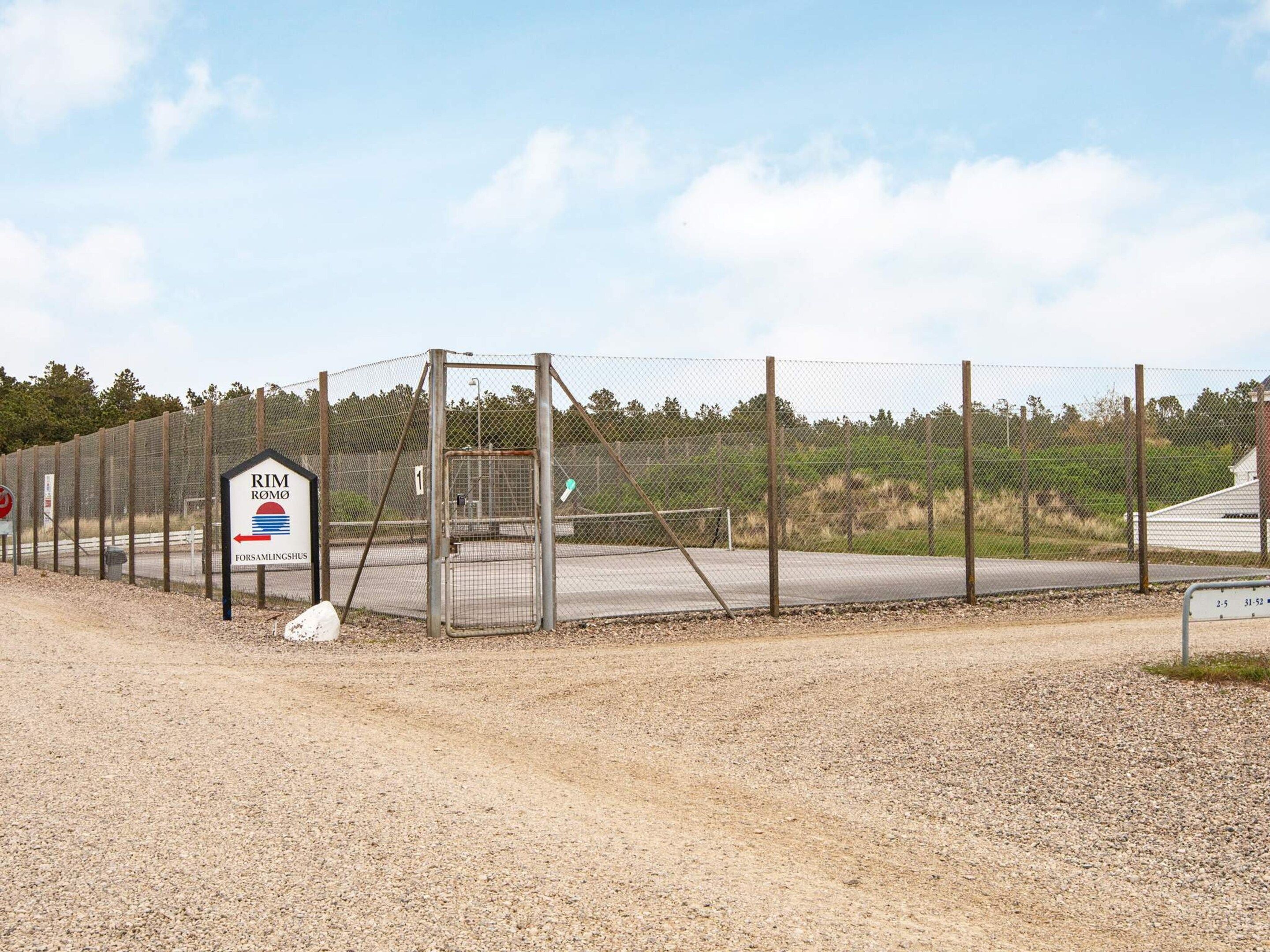 A fenced area with a sign indicating 'RIM ROMO' and 'FORSAMLINGSHUS'.