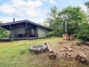 A modern house with a covered porch, a fire pit, and outdoor furniture. - 4 Person Holiday Home in Skibby (Skibby)