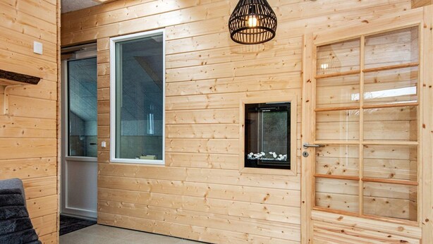 A wooden interior with a sofa, a small table, and a door with a grid pattern. - 8 Person Holiday Home in Ebeltoft-by Traum (Ebeltoft)