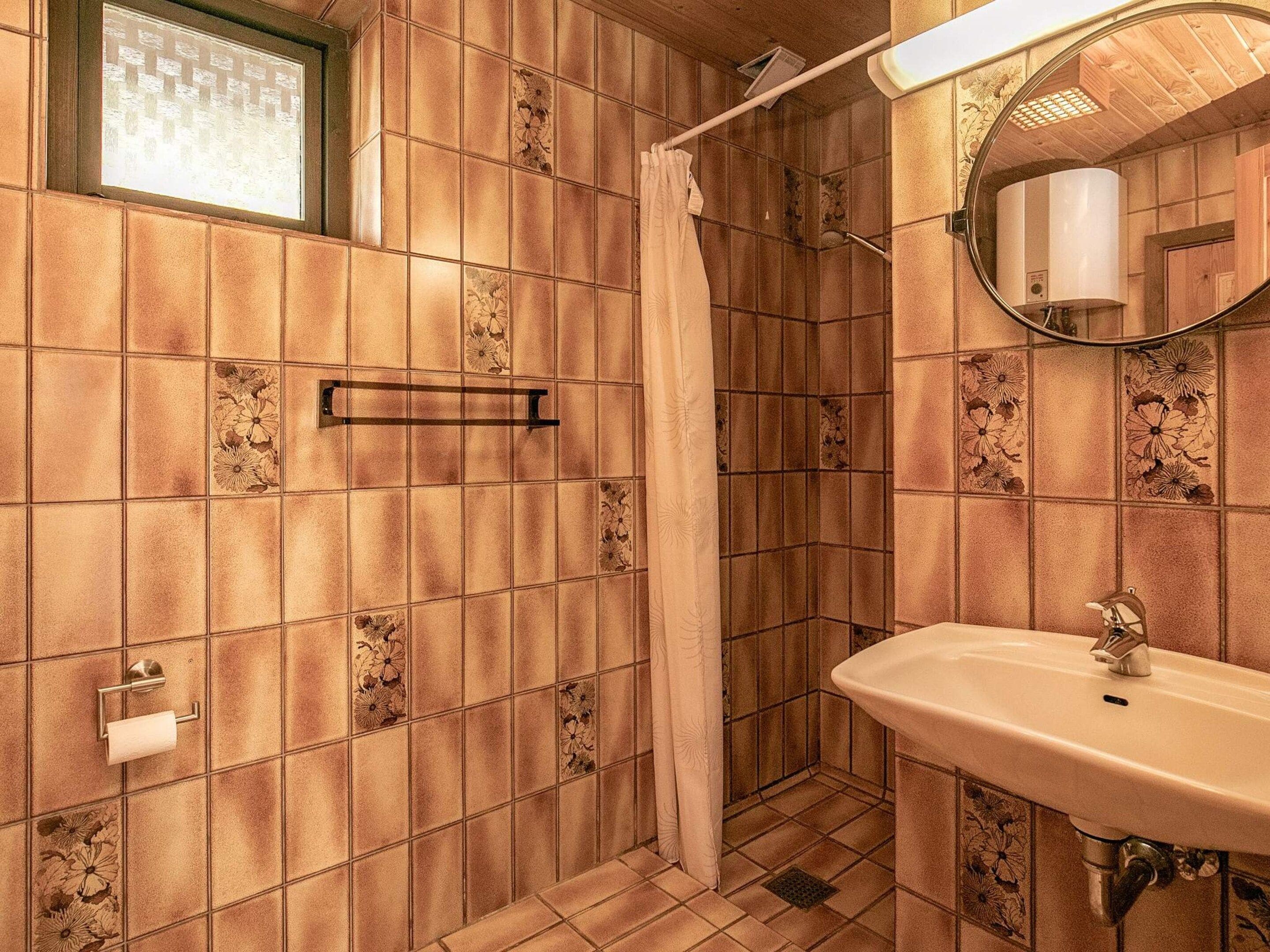 A bathroom with a shower, a sink, and a mirror.