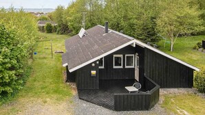 Une petite cabane en bois d’un seul étage, avec un toit en pente, une véranda dotée d’une seule chaise et le numéro « 16 » bien visible sur la porte.