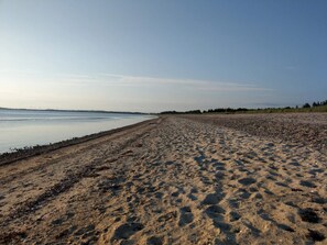 A wide sandy beach with a calm sea, a clear sky, and a distant shoreline. - Rustic Holiday Home in Logstor near Beach (Logstor)