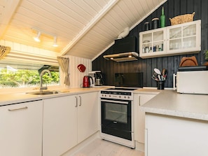 A modern kitchen with a stove, oven, and a coffee maker. - 6 Person Holiday Home in Humble (Sydlangeland)