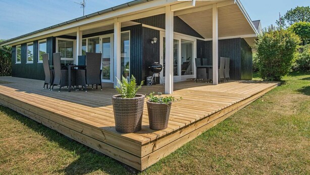 A modern house with a covered patio, large windows, and a deck. - 6 Person Holiday Home in Allingabro-by Traum (Allingåbro)