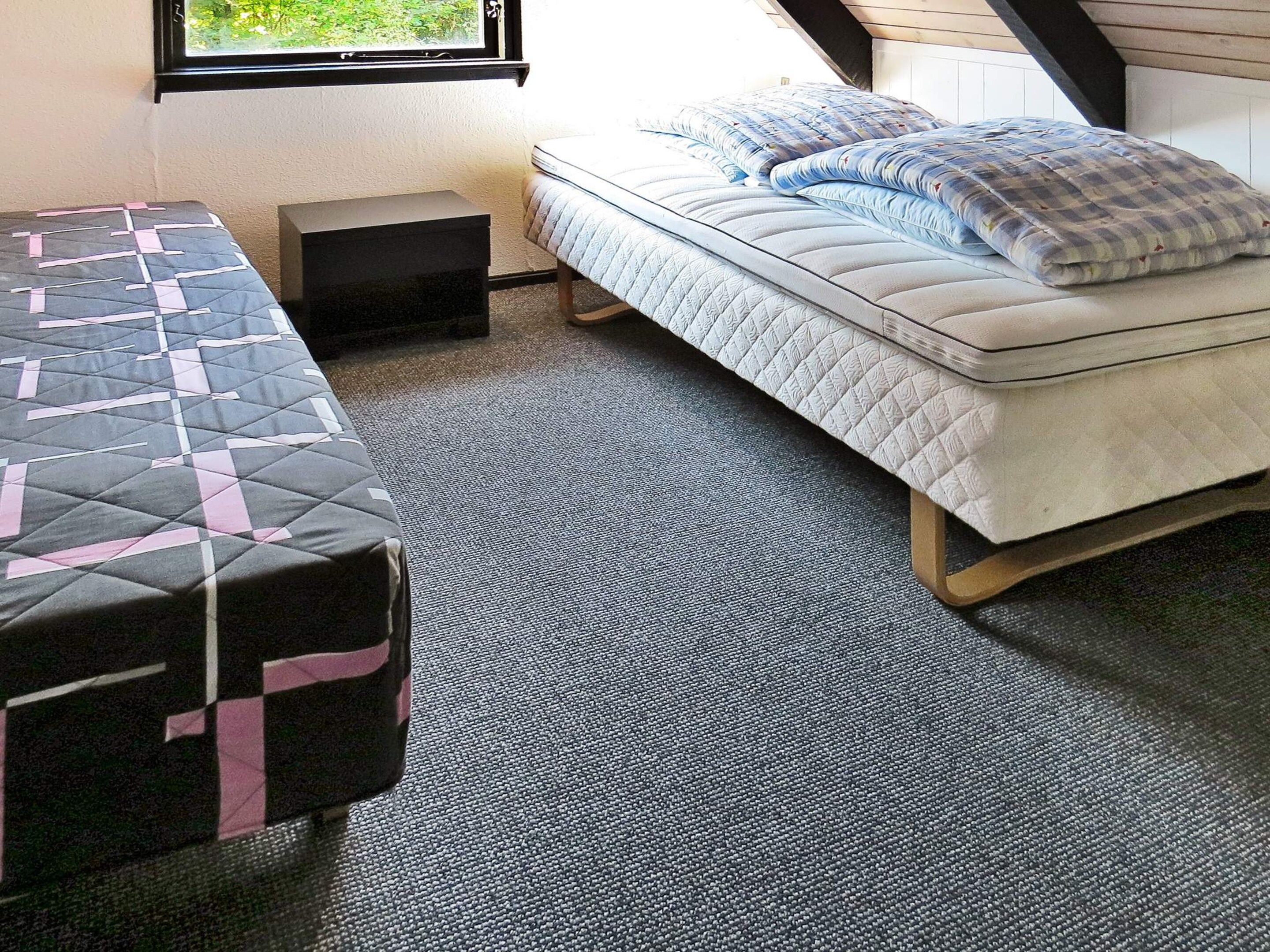 A room with a bed, a small table, and a window.