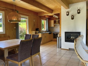 A wooden interior with a dining table, chairs, a kitchen area, and a fireplace. - Luxury chalet with magnificent views and a large terrace (Stadl an der Mur)