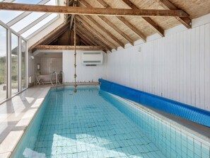 A swimming pool with a wooden ceiling and a view of the outdoors. - 12 Person Holiday Home in Hvide Sande (Hvide Sande)