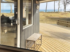 A wooden deck with a view of the beach and ocean.