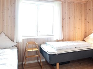 Una habitación con una cama, una escalera de madera y una ventana.