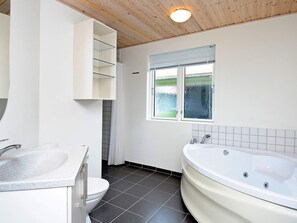 A bathroom with a toilet, sink, and bathtub. - 5 Star Holiday Home in Ulfborg (Ulfborg)