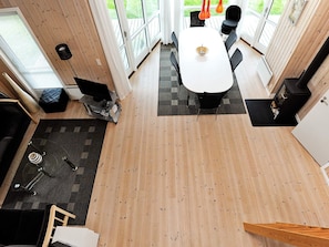 A modern interior with a dining area, a sofa, a TV, and a fireplace.