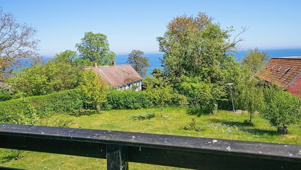 A coastal view with a house, trees, and a clear sky. - 8 Person Holiday Home in Allinge (Allinge)