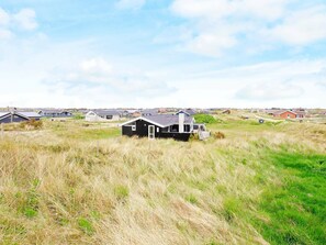 A row of houses in a grassy area with a clear sky. - Sprawling Holiday Home at Hvide Sande With Indoor Whirlpool (Hvide Sande)