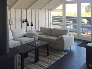 Una sala moderna con un sofá modular, una mesa de centro y lámparas colgantes.