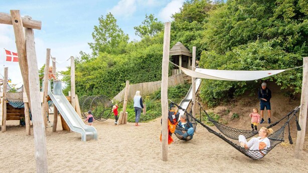 A playground with a slide, swings, and a hammock. - 8 Person Holiday Home in Egernsund (Broager)