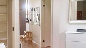 A hallway with a wooden floor, a white dresser, and a small wooden stool. - 8 Person Holiday Home in Egernsund (Broager)