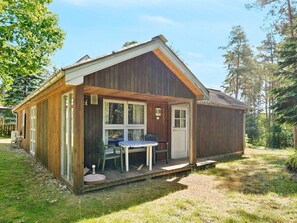 A wooden cabin with a porch, a table, and chairs. - 7 Person Holiday Home in Kolind-by Traum (Kolind)