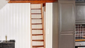 A wooden staircase leading to a kitchen area with a stainless steel oven and a black cabinet. - 4 Star Holiday Home in Urangsvag (Bomlo)