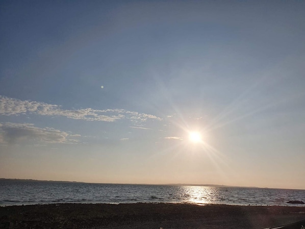 A beach scene with the sun low on the horizon, clear sky, and calm sea. - 19 Person Holiday Home in Logstor-by Traum (Logstor)
