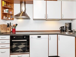 A kitchen with white cabinets, a stainless steel range hood, a dishwasher, and a coffee maker. - 19 Person Holiday Home in Logstor-by Traum (Logstor)